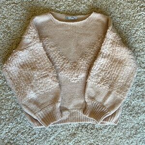 Soft pink winter pull over with intricate knitted detail.